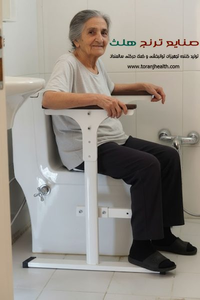 مادر بزرگ که در سرویس بهداشتی روی توالت فرنگی نشسته است و به جهت ایمنی و راحتی نشستن و بلند شدن ، از نیرو دست ها کمک میگیرد.