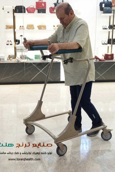 مرد سالمند برای راه رفتن از واکر چرخدار ایستاده کمک گرفته است.